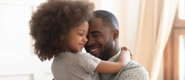 African descent man hugging their child lovingly while carrying them on their arms | Kenyan Parental Responsibility Agreement | Njaga & Co. Advocates family law firm
