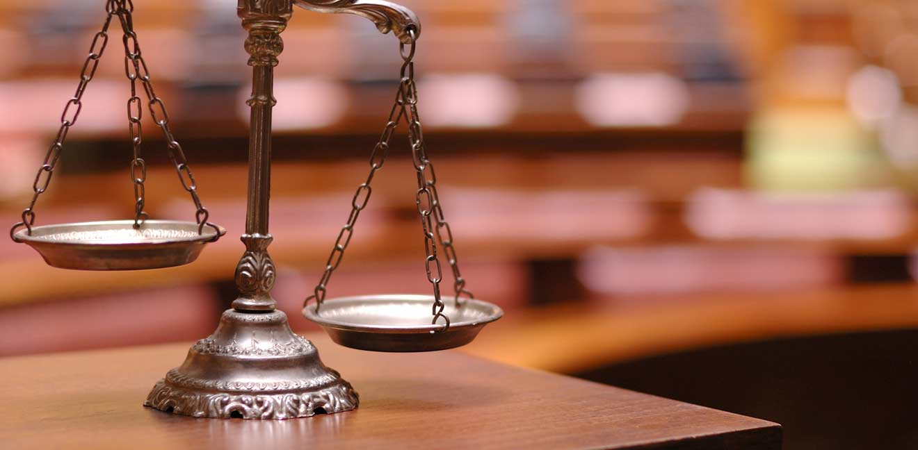 litigation-ing scales of justice on a wooden table