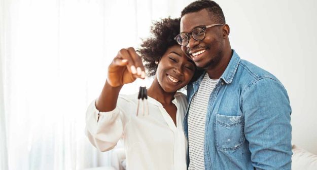 Couple all smiles hugging as the lady holds a key inside a house | Co-owning Property in Kenya | Njaga Advocates property law