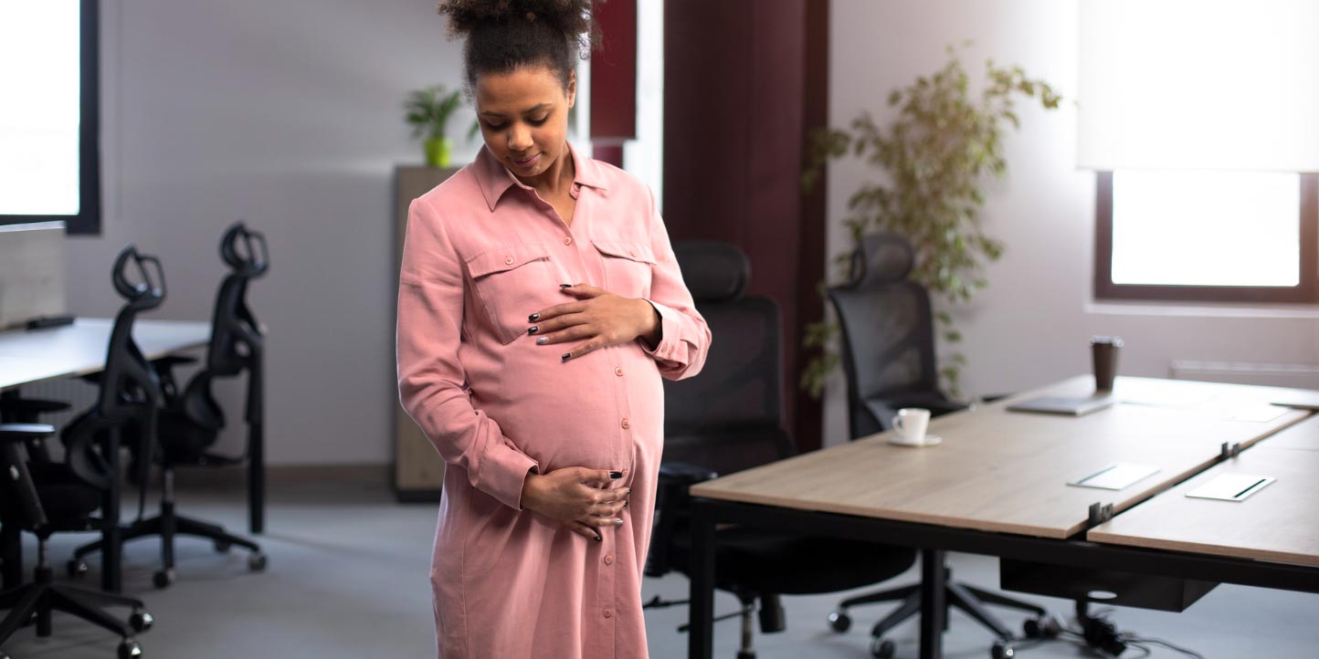 pregnant woman admiring and holding her belly in an office | Maternity and Paternity Leaves in Kenya under the Employment Act | Njaga & Co Advocates employment and labour law firm in Kenya