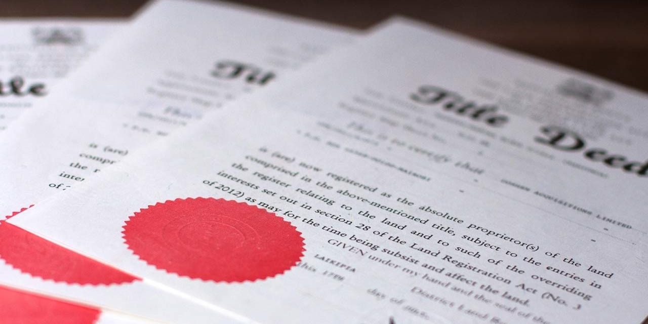 land act 2012 Title deed documents on a table | Resolving Disputes in Jointly Owned Property in Kenya: Legal Remedies under the Land Registration Act, 2012 | Real Estate lawyers in Nairobi | Njaga & Co. Advocates