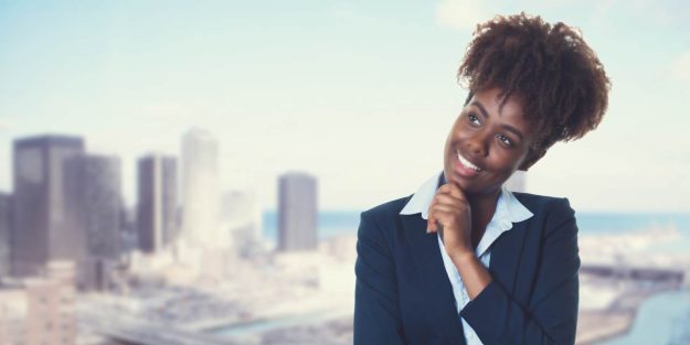 African descent lady smiling while holding her chin looking up with a city background | A Guide for Foreign Investors Starting a Business in Kenya | Foreign investment in Kenya | Njaga & Co Advocates Corporate Commercial lawyers | Immigration law advisory in Nairobi